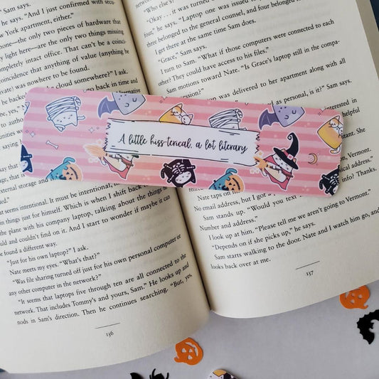 Colorful Halloween bookmark with cats in costume carrying pumpkins and candy on pink and orange stripes